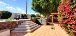 Backyard patio with sun loungers, gas chimenea, and BBQ